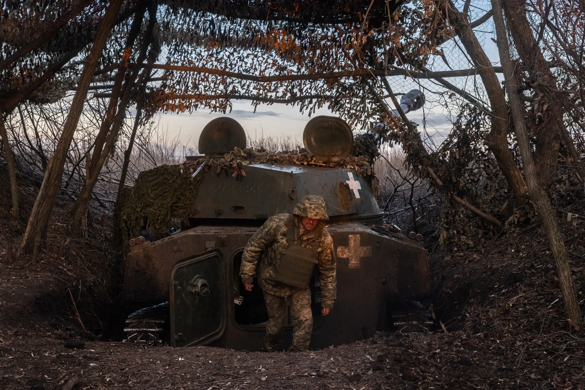 Українські бійці 44-ї бригади виходять із самохідної гаубиці, захованої в прифронтовій купі дерев, перед обстрілом позицій росіян біля Борова-Сватового на Харківщині 6 грудня.